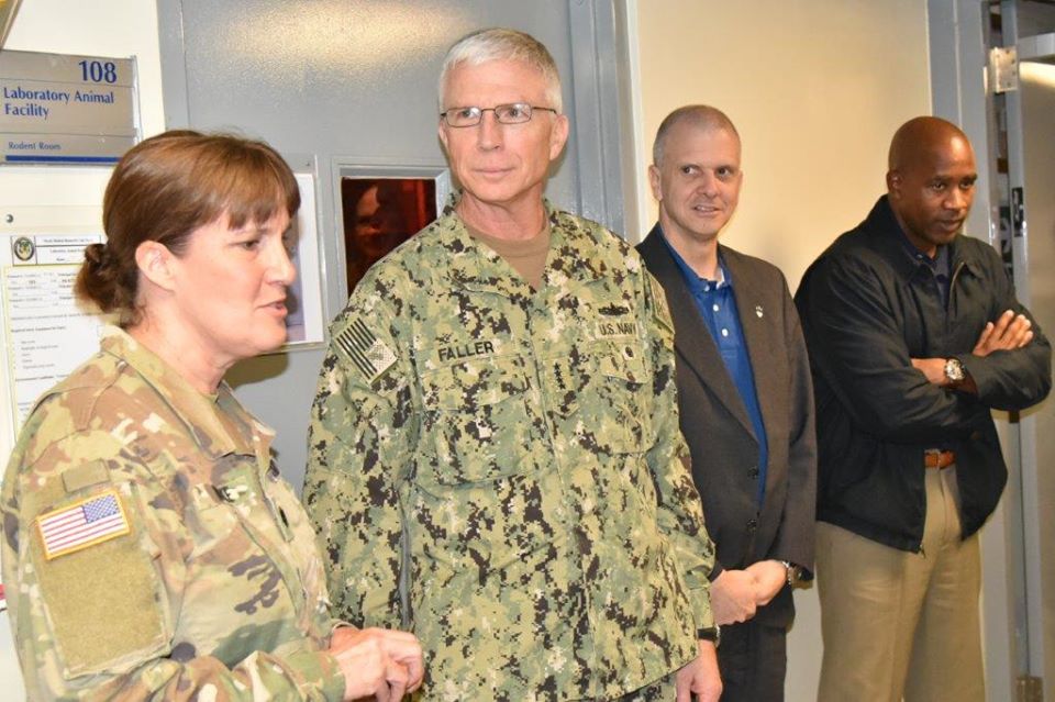 LTC Burke (L), Head of the Animal Facility, discusses current research activities with ADM Faller and SOUTHCOM visitors.